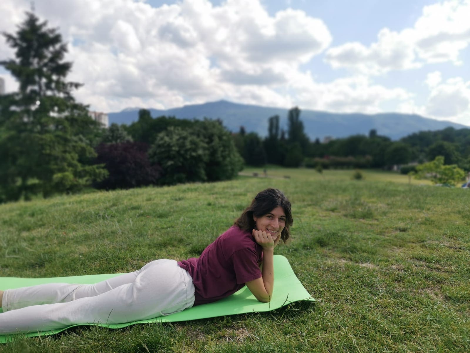 Fedra relaxing on a yoga mat outdoors
