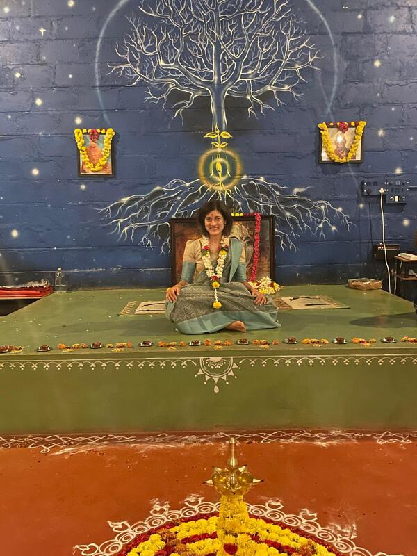 Fedra sitting in meditation in a vibrant blue space in India