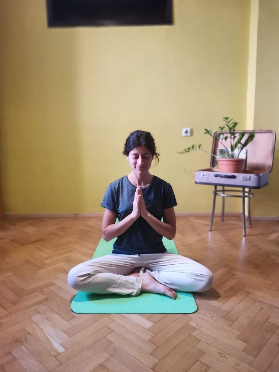 Fedra sitting in peaceful meditation with grey shirt